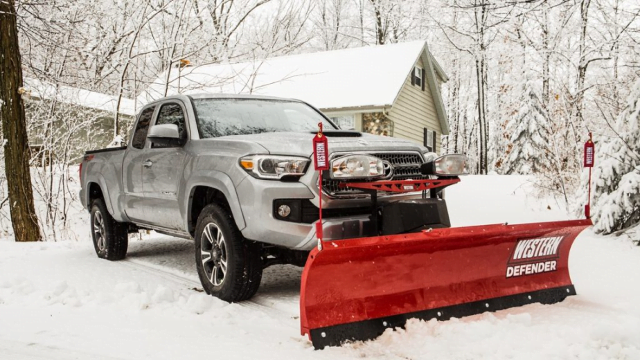 Picture of silver truck with a Western Defender snow plow attached in the snow.